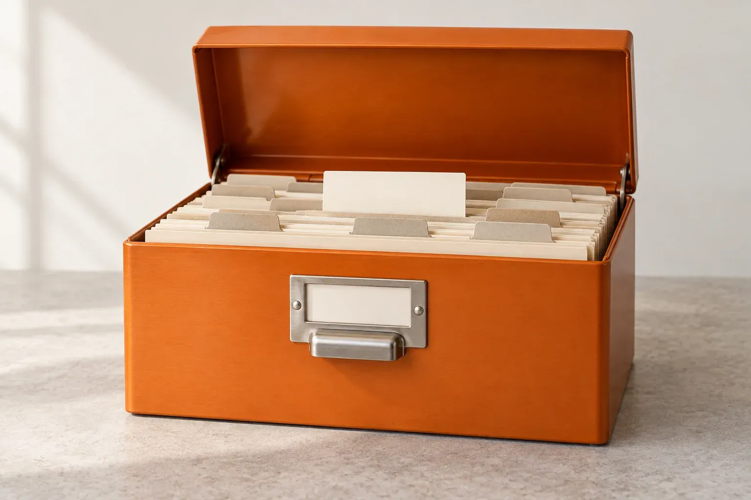 An orange card-index box holds neatly arranged cream product reference cards.